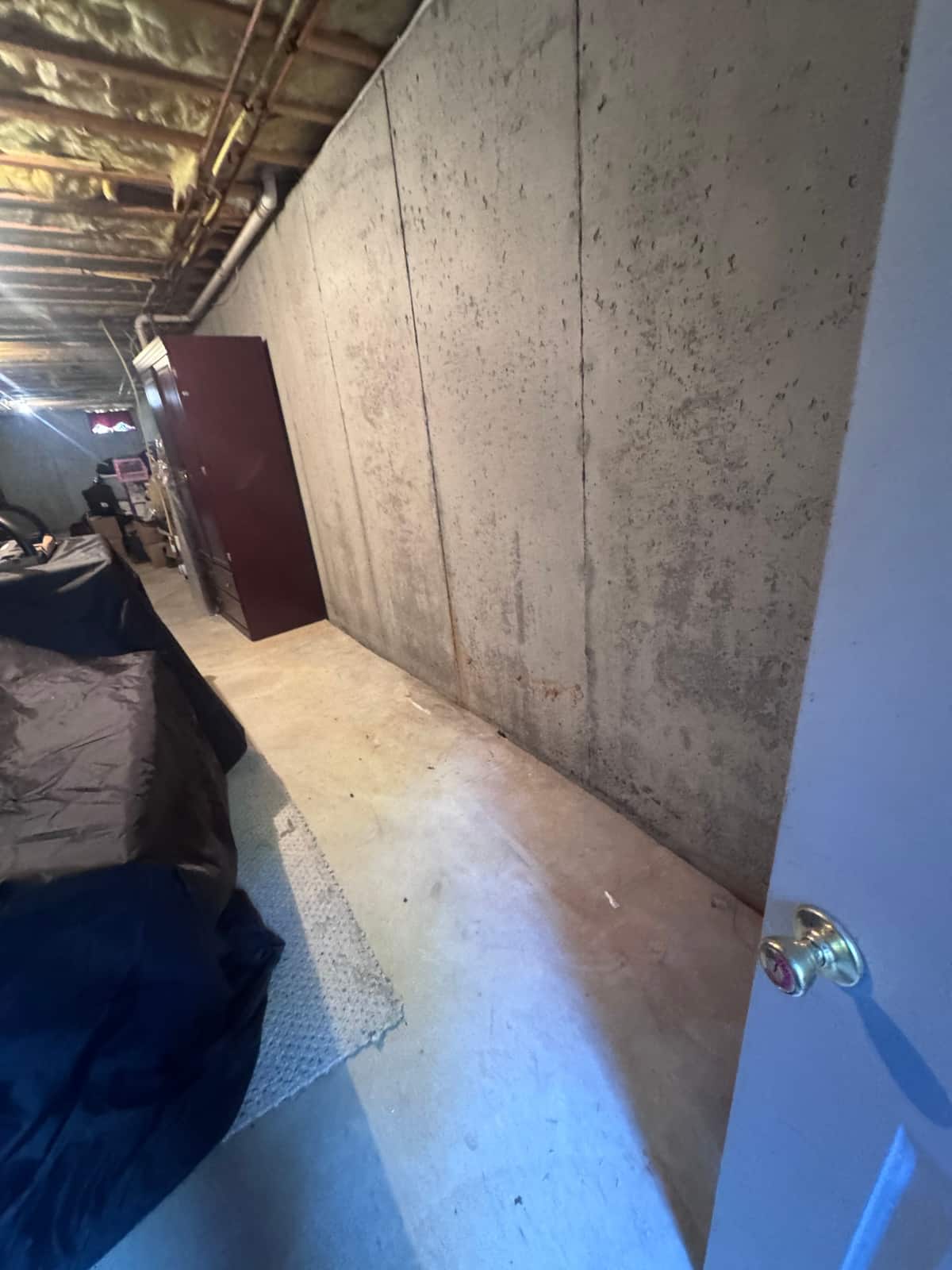 The same basement cleared, with an open floor running along the concrete wall