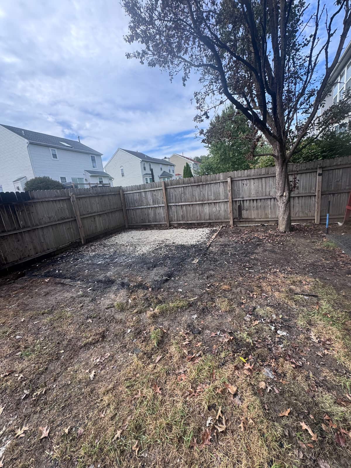 The same Newark backyard after the burned shed was removed, with the gravel pad and bare ground left behind