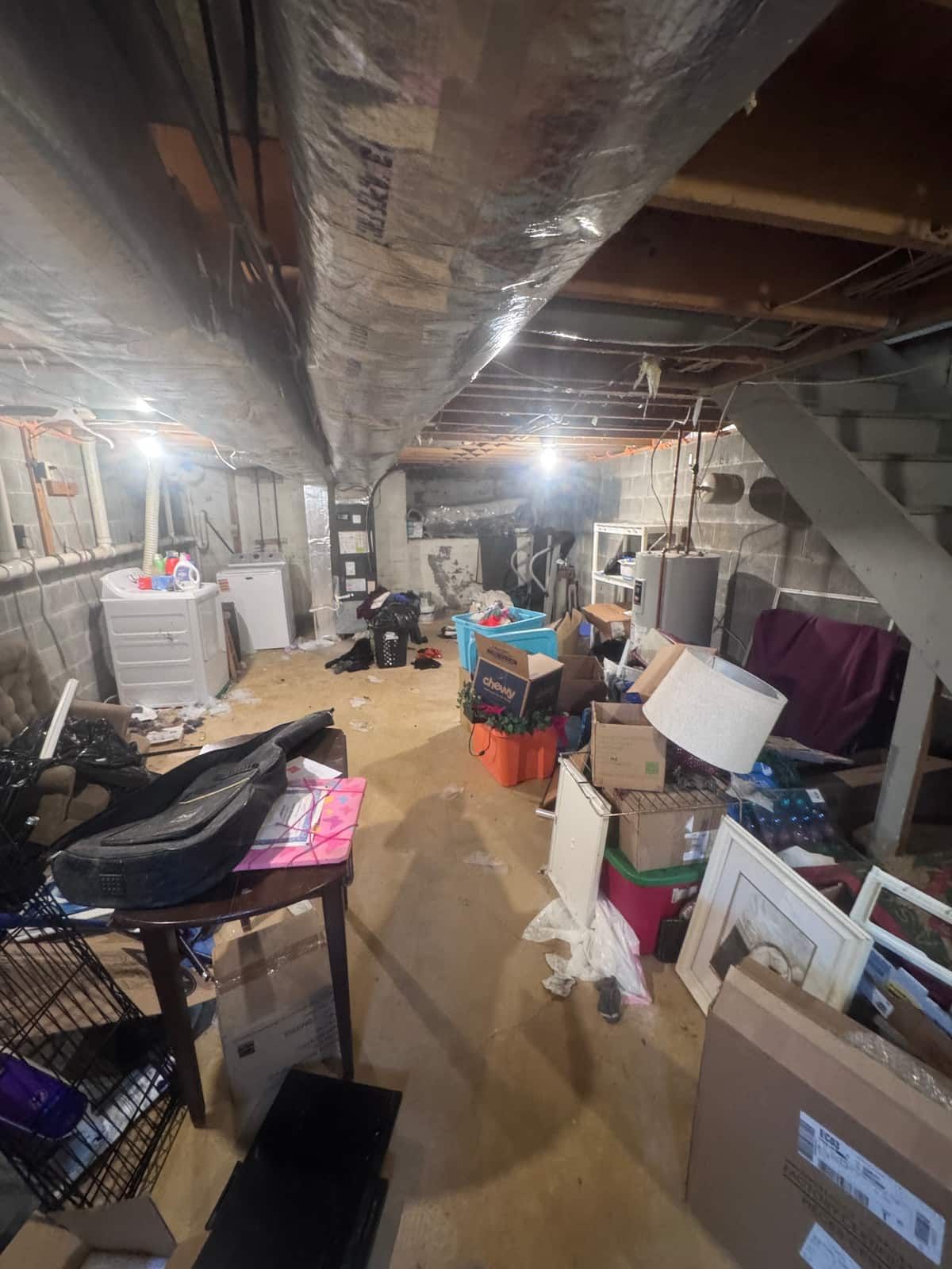 The unfinished basement of the same Newark townhouse, crowded with boxes, bins and furniture