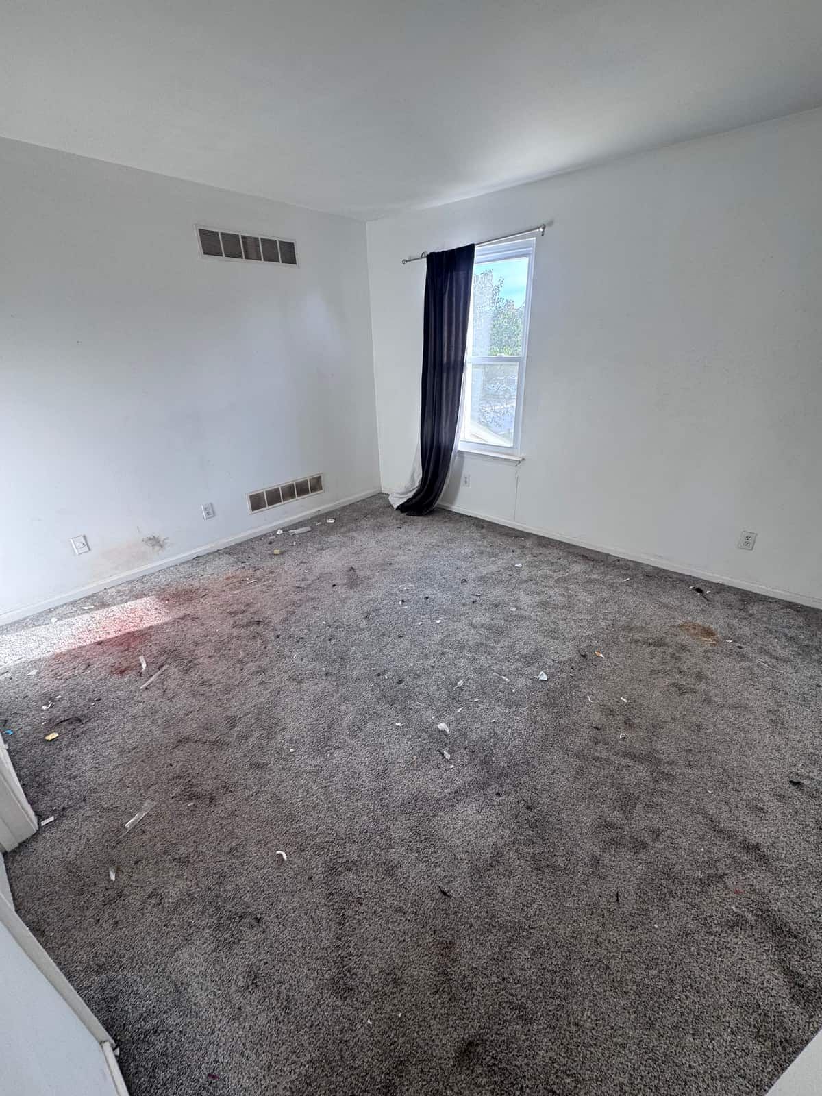 The same bedroom emptied down to the carpet