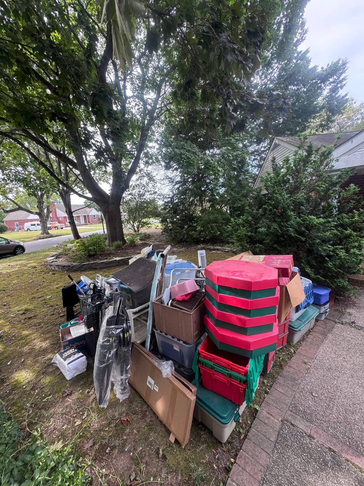 Boxes, storage bins and household items staged on the front lawn of a Dover home before the cleanout